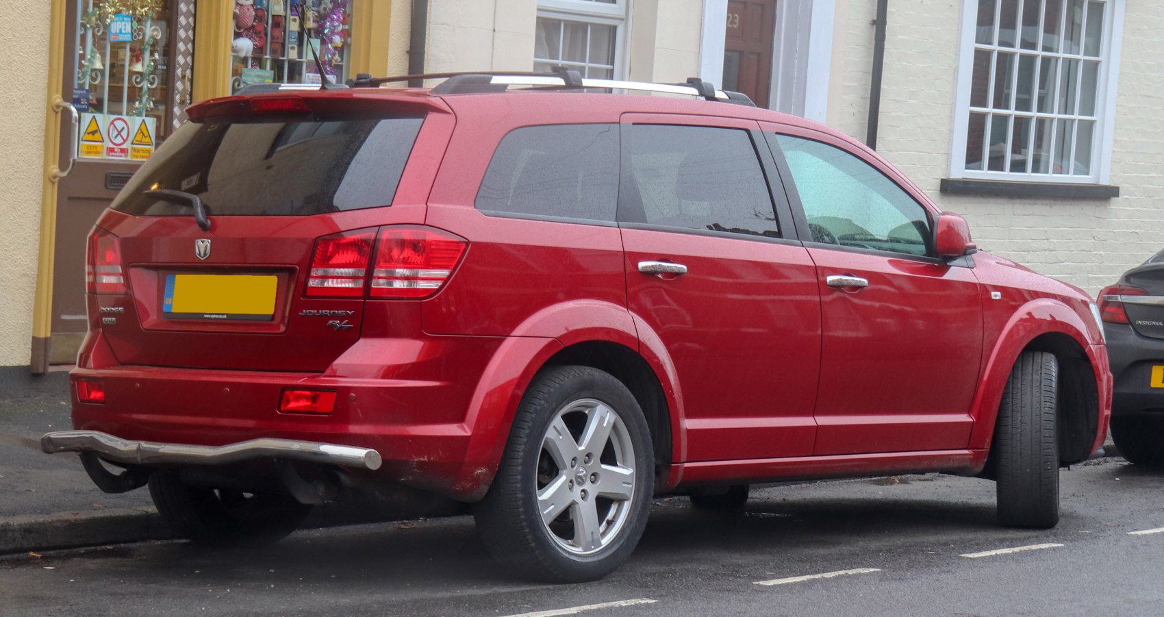 Rear side view of red SUV with roof rails and alloy wheels