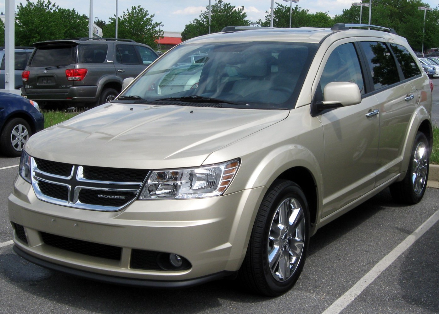 Front view of mid-size SUV with chrome wheels and roof rack