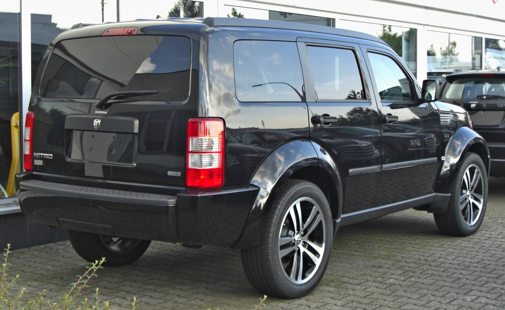 Rear and side view of a black SUV with tinted windows and alloy wheels