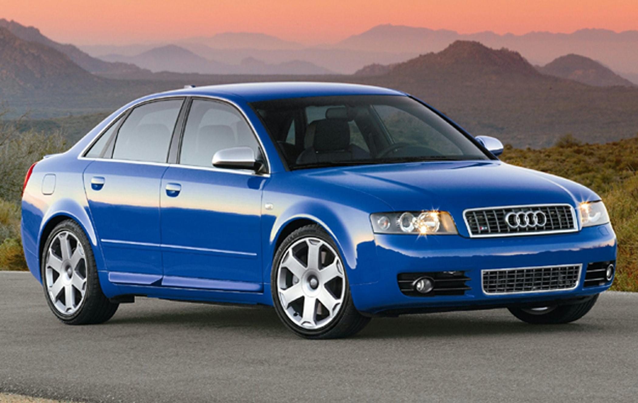 Front side view of blue sedan showing headlights and alloy wheels