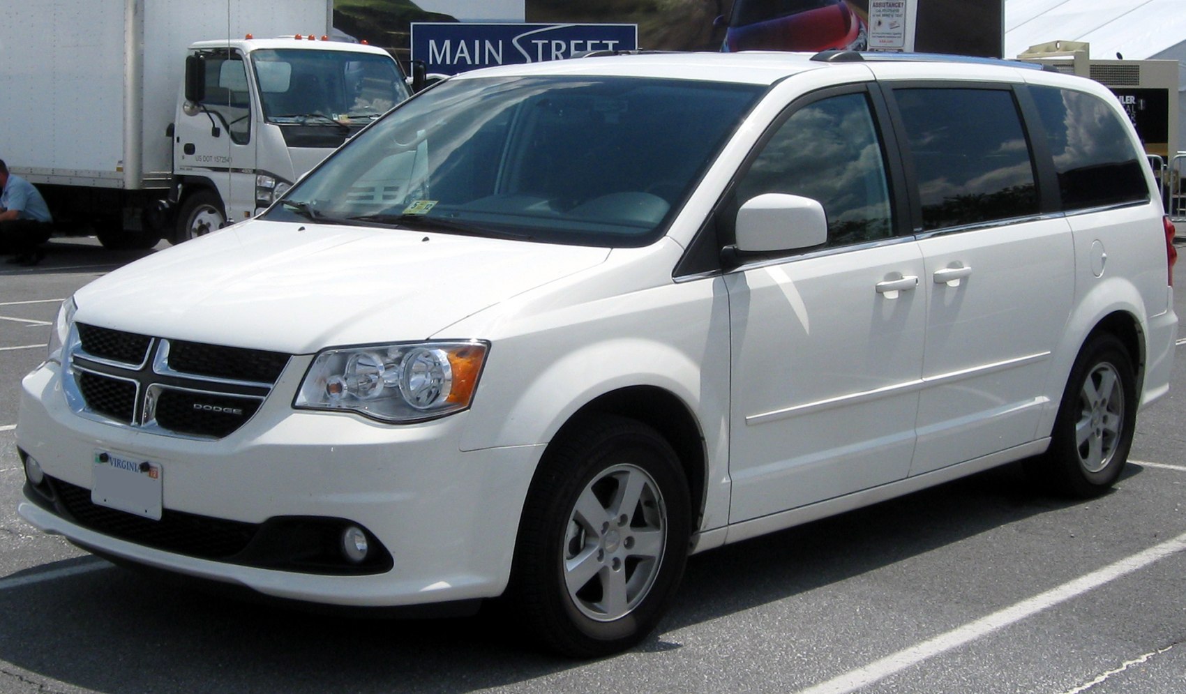 White minivan with front and side profile, clear outdoor parking.