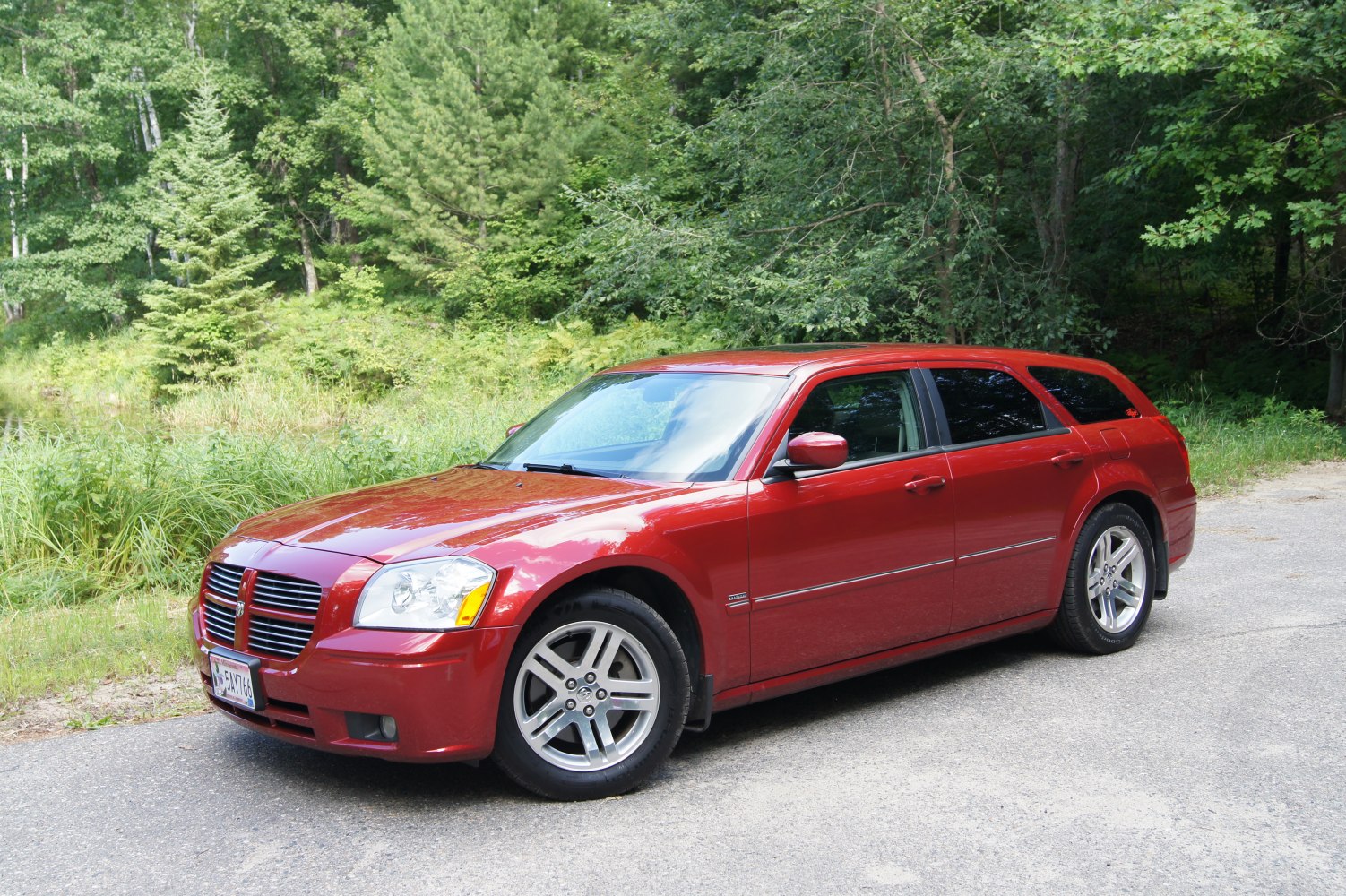 Red sporty wagon with alloy wheels in outdoor natural setting