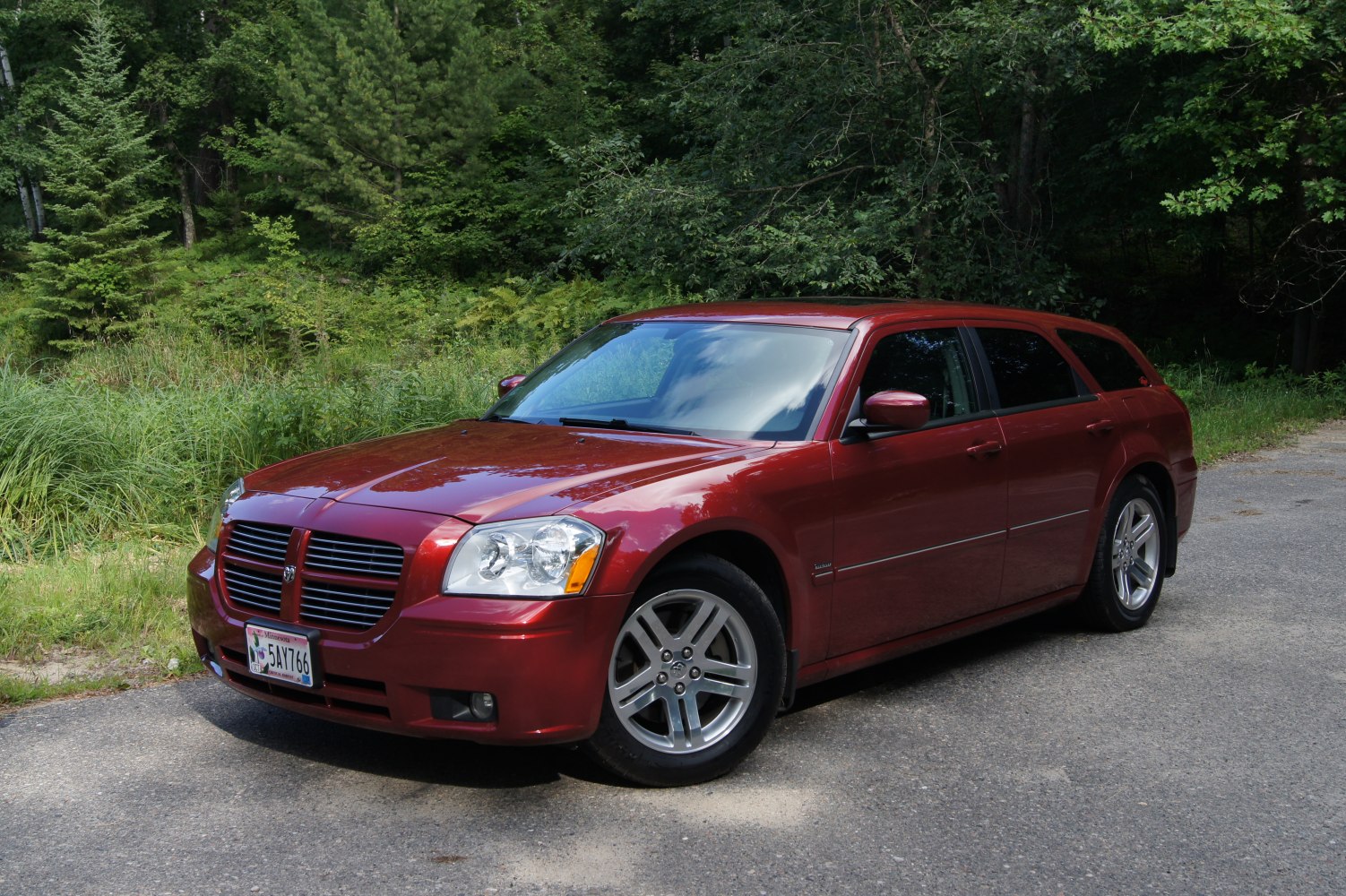 Red station wagon with classic grille and alloy wheels.
