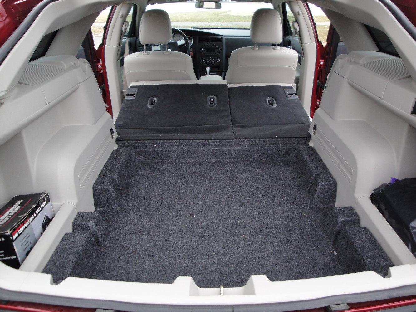 Large carpeted cargo space with folded rear seats and rear view of vehicle interior