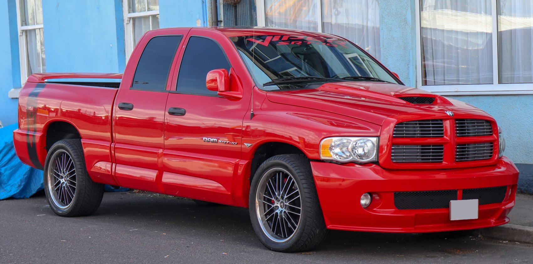 Sporty red pickup truck with hood scoop and custom wheels