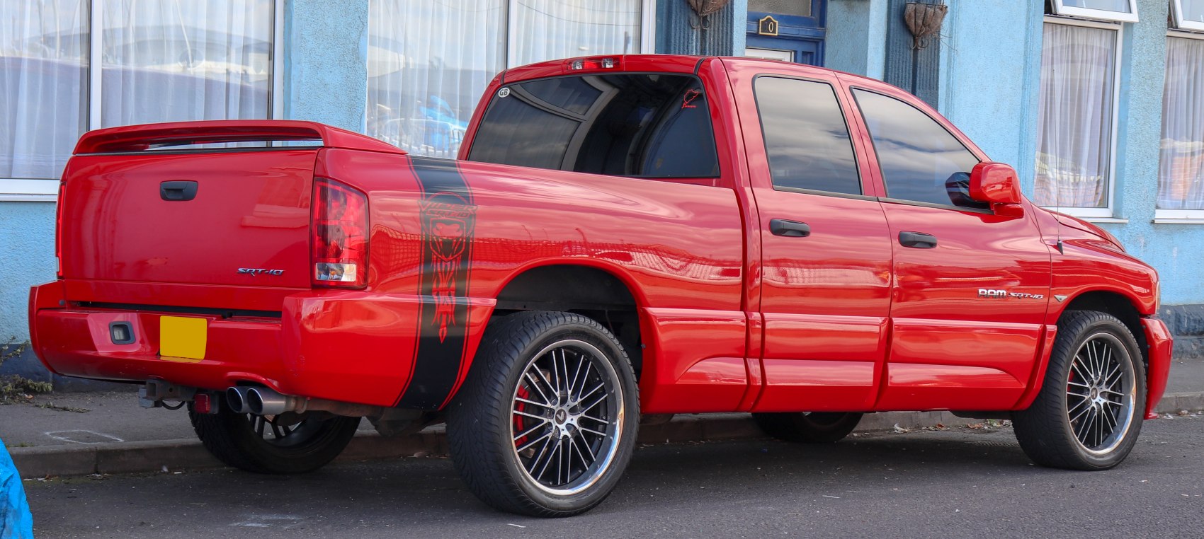 Red pickup truck with custom wheels and rear spoiler