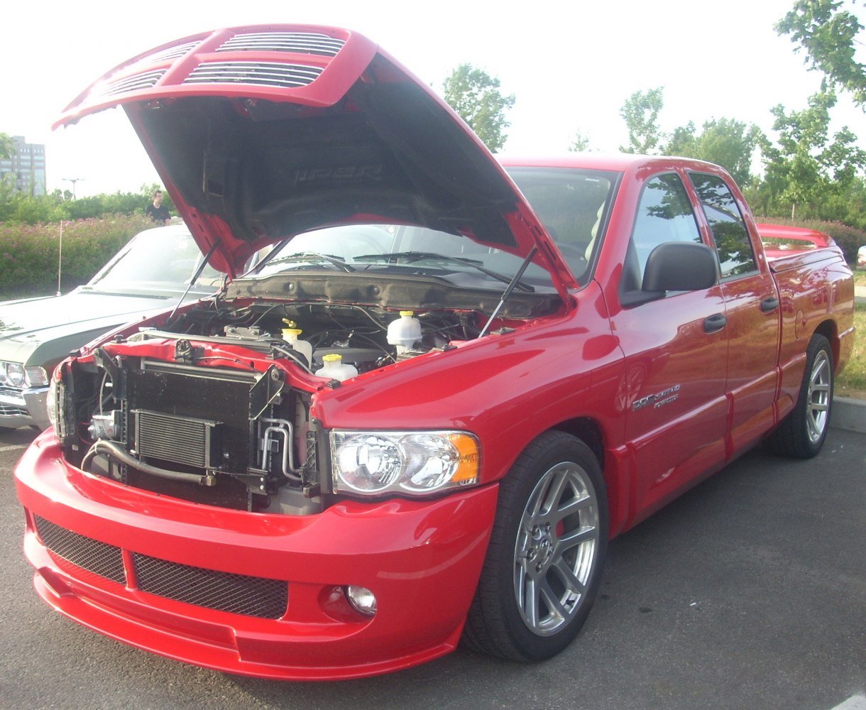 Pickup truck with open hood showing engine bay and front grille