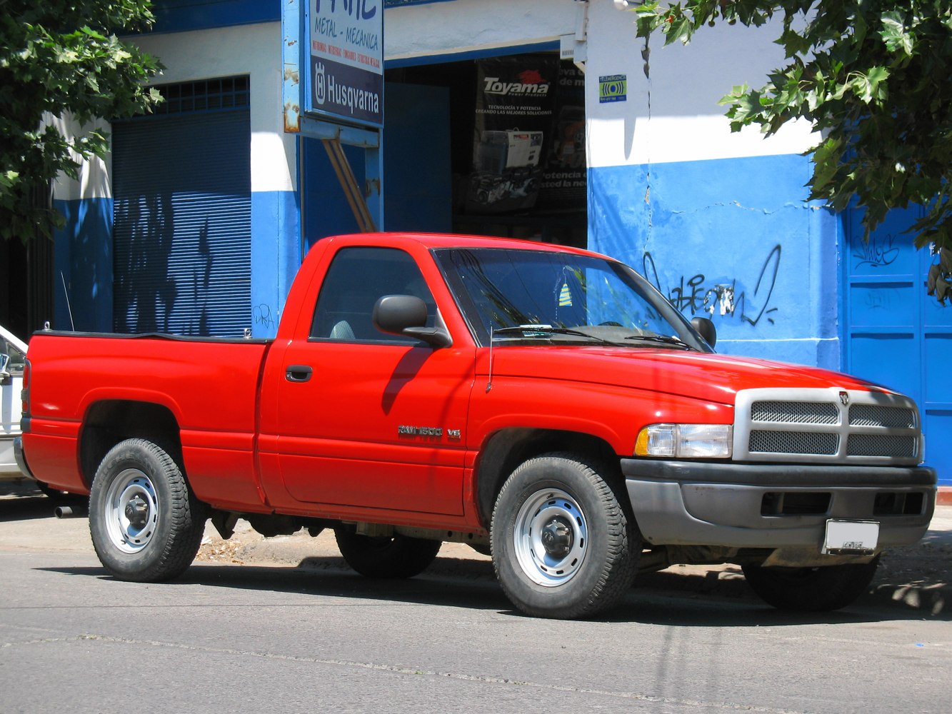 Side profile of red regular cab short bed pickup with steel wheels