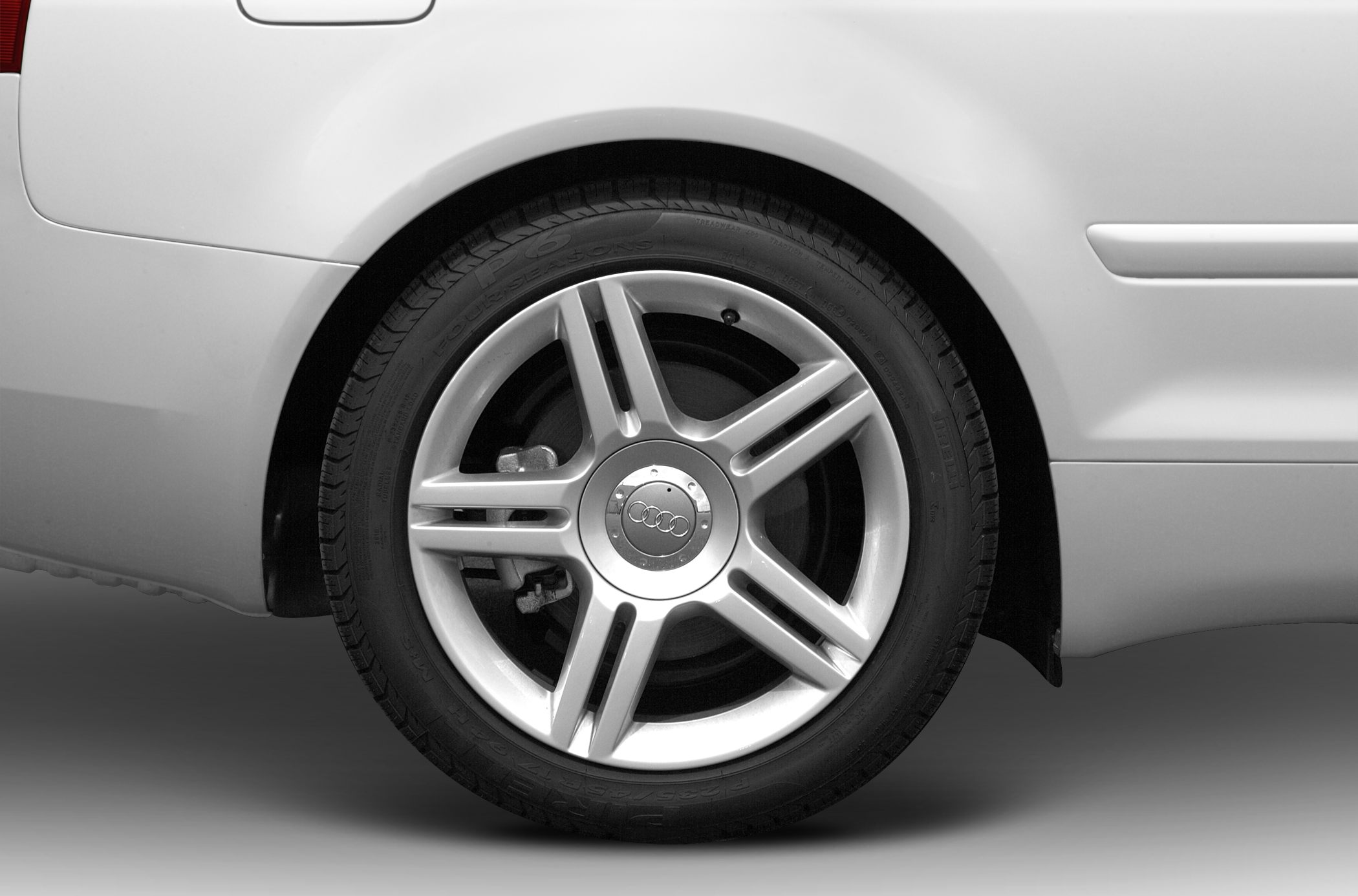 Close-up of rear 5-spoke alloy wheel and tire with brake assembly