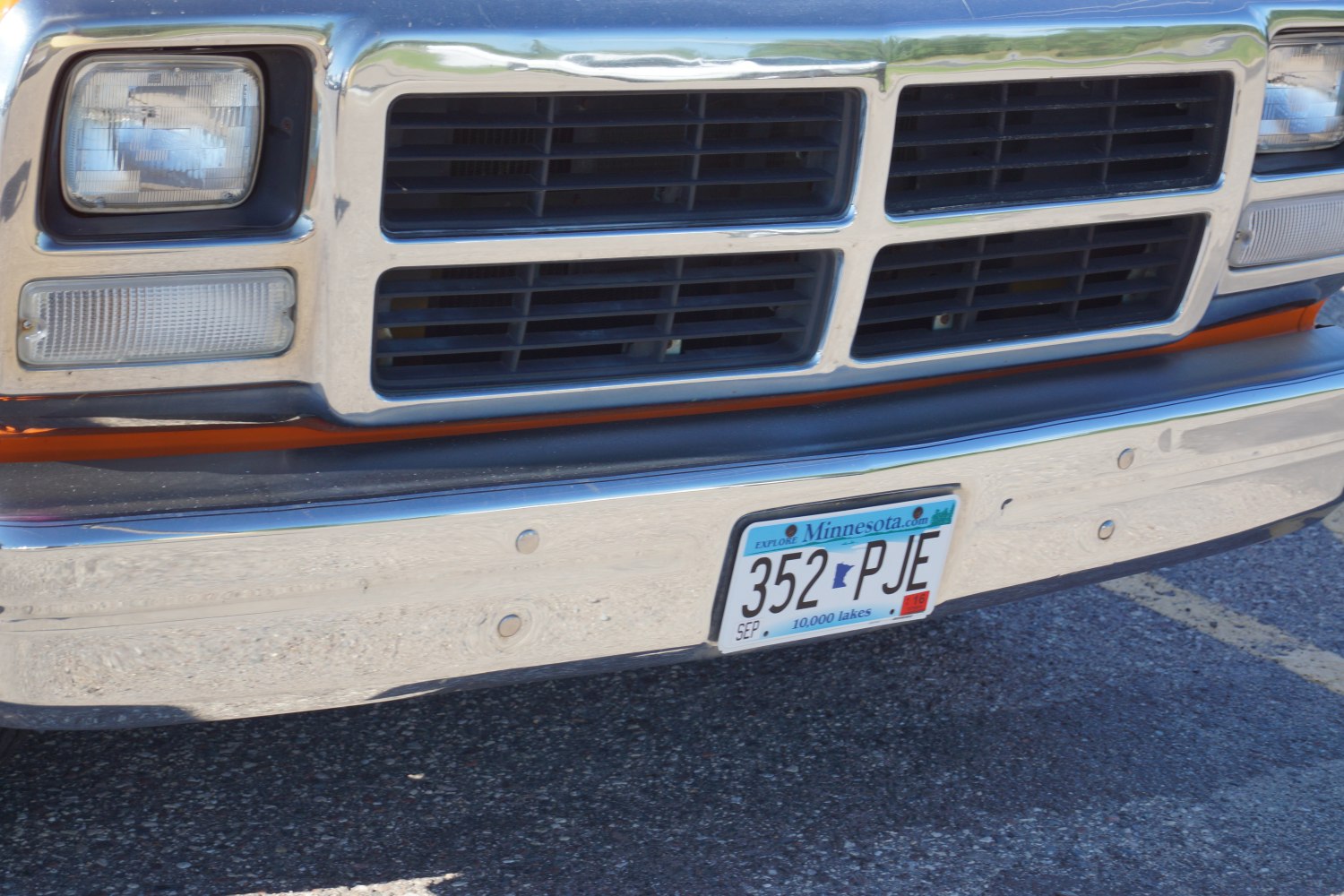 Front grille, rectangular headlights, and chrome bumper close-up