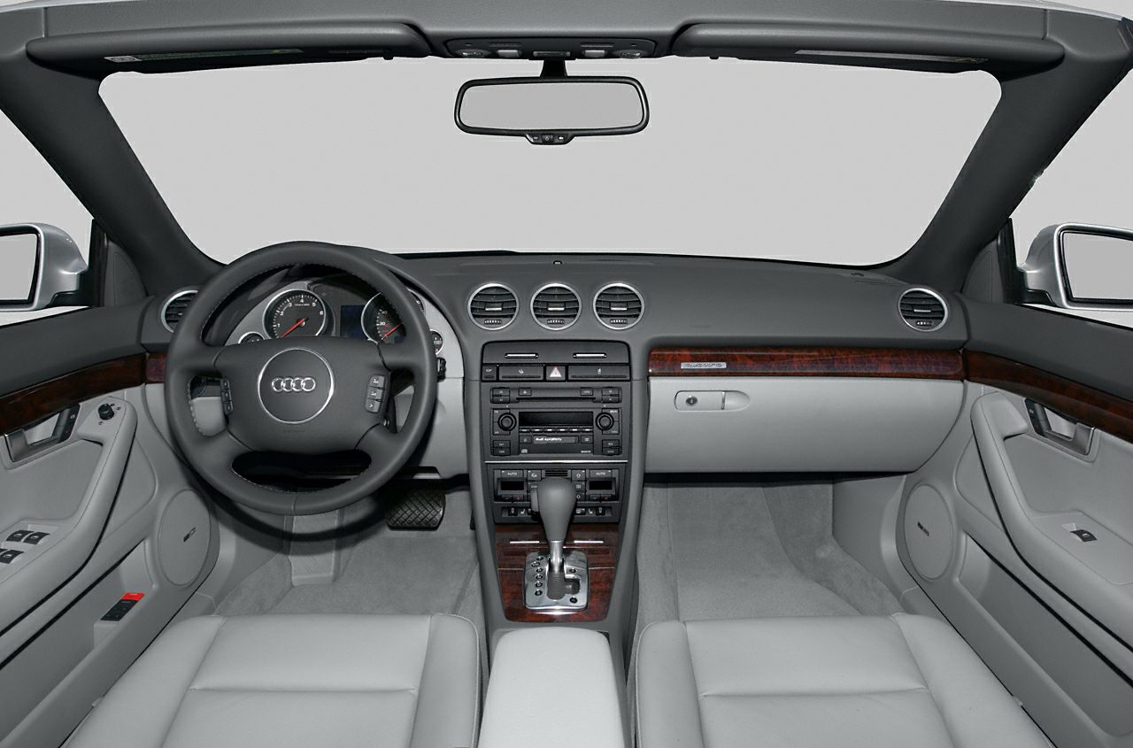 Interior dashboard, steering wheel, and center console with wood trim