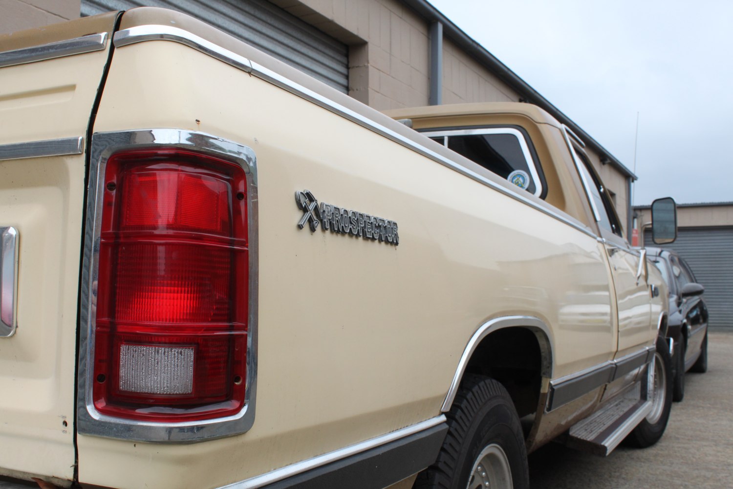 Long bed pickup truck rear side with red taillight and Prospector badge
