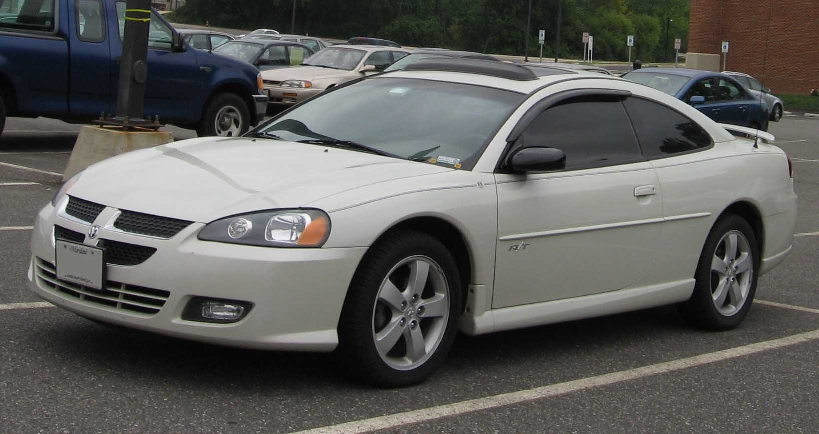White sports coupe with rear spoiler and tinted windows