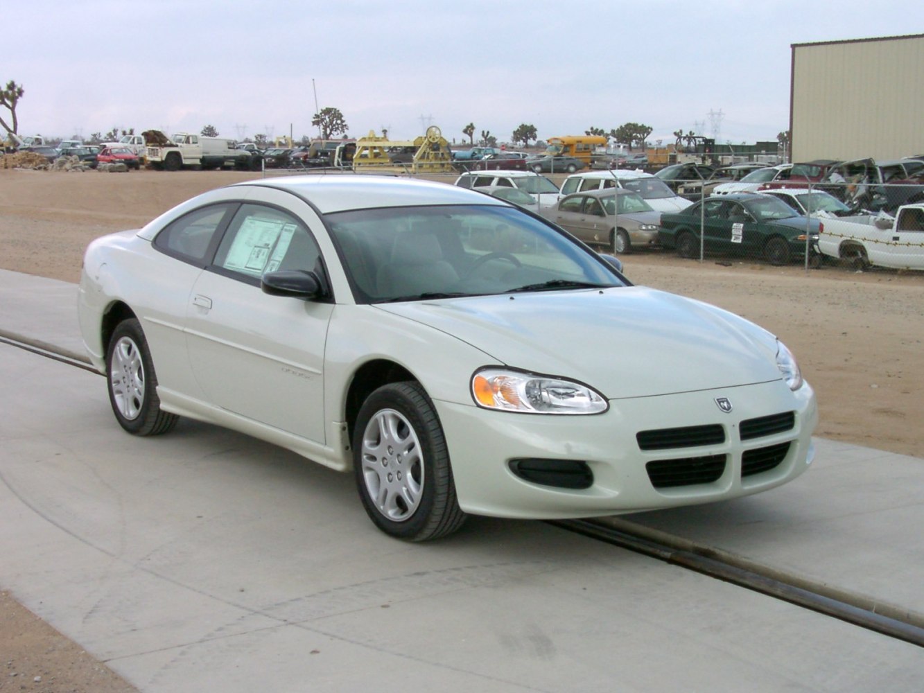 Front side view of a two-door coupe with smooth body lines and signature headlights