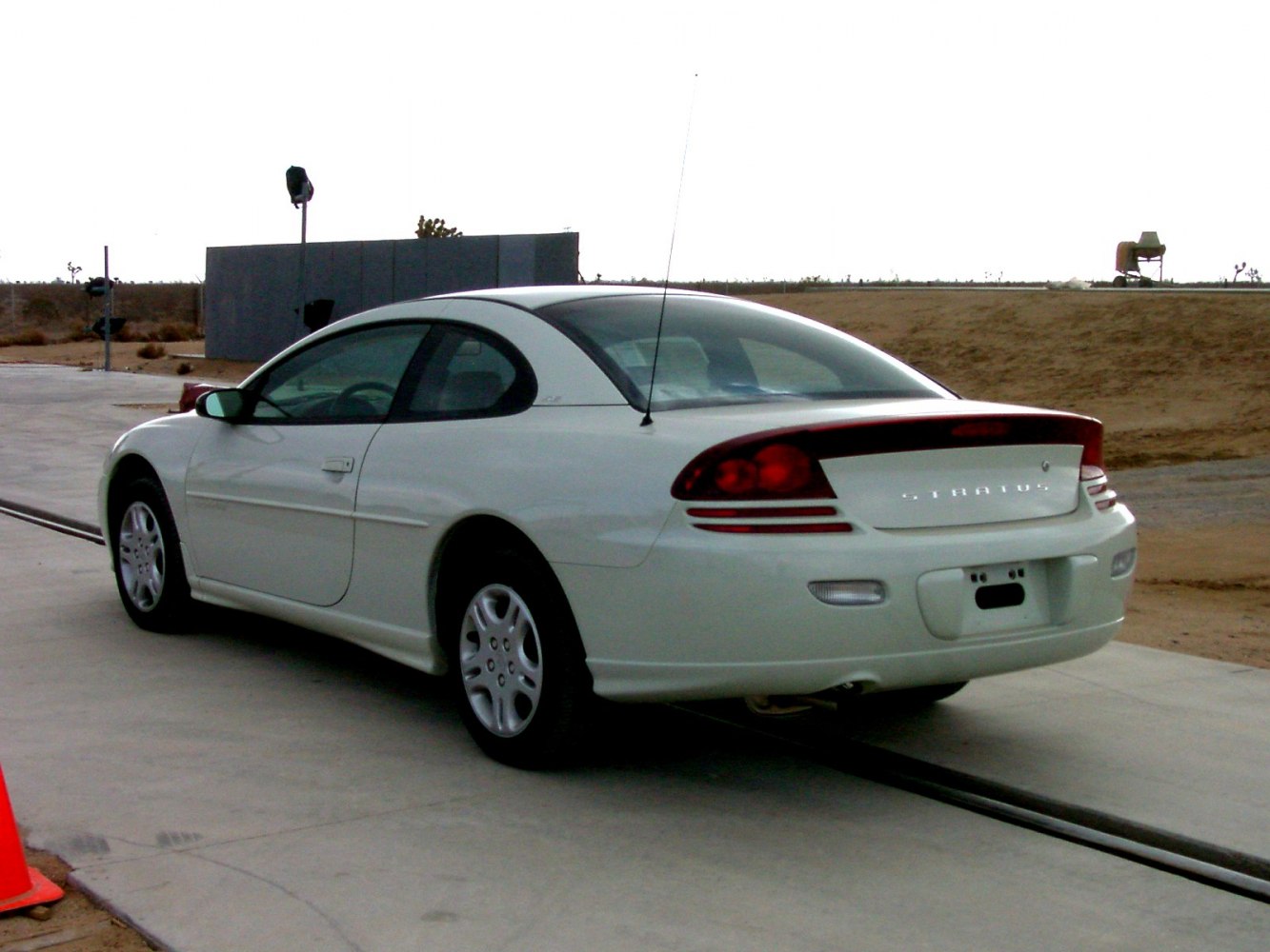 Rear and side profile of a white coupe with sleek taillights
