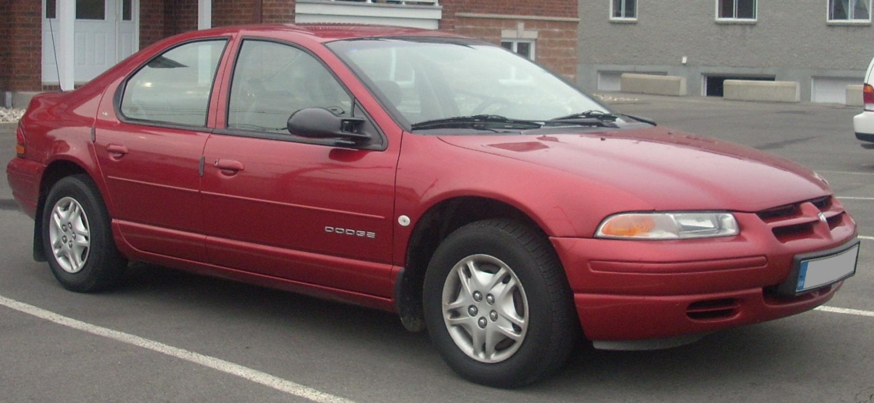 Red mid-90s four-door sedan with smooth body lines and distinctive grille