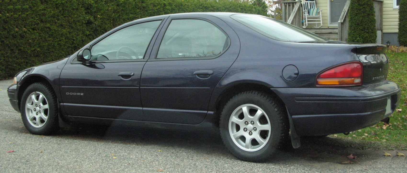 Side profile of a sedan with rear spoiler and alloy wheels