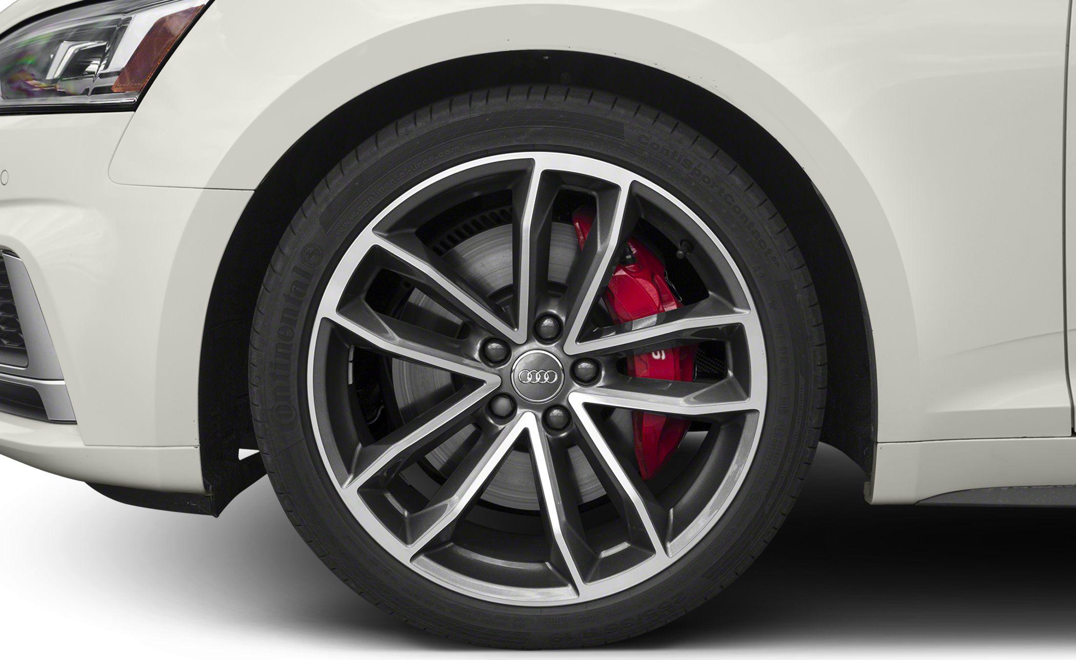 Sporty alloy wheel with red brake caliper on white vehicle