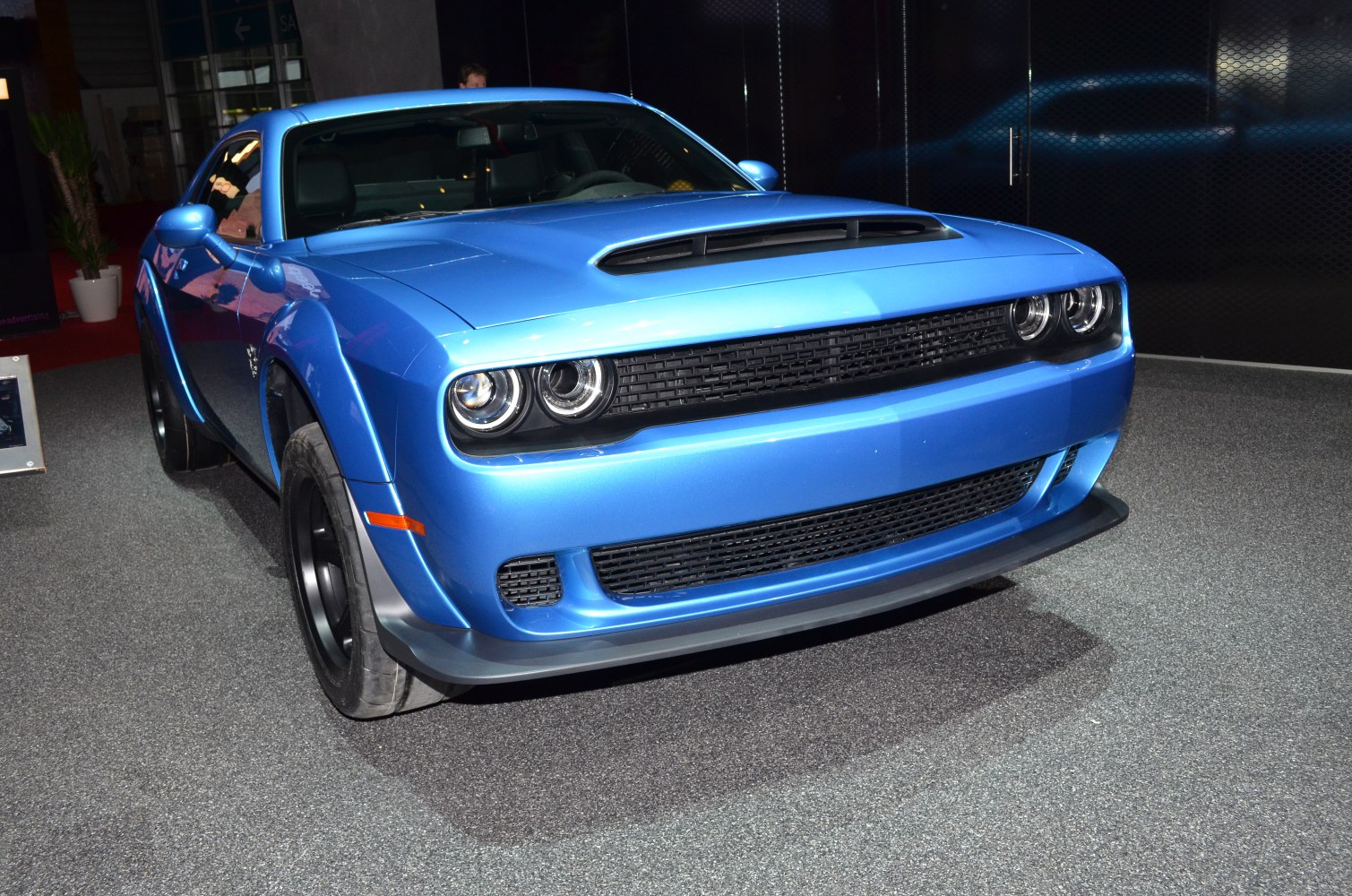 Blue muscle car front with dual headlights and hood scoop
