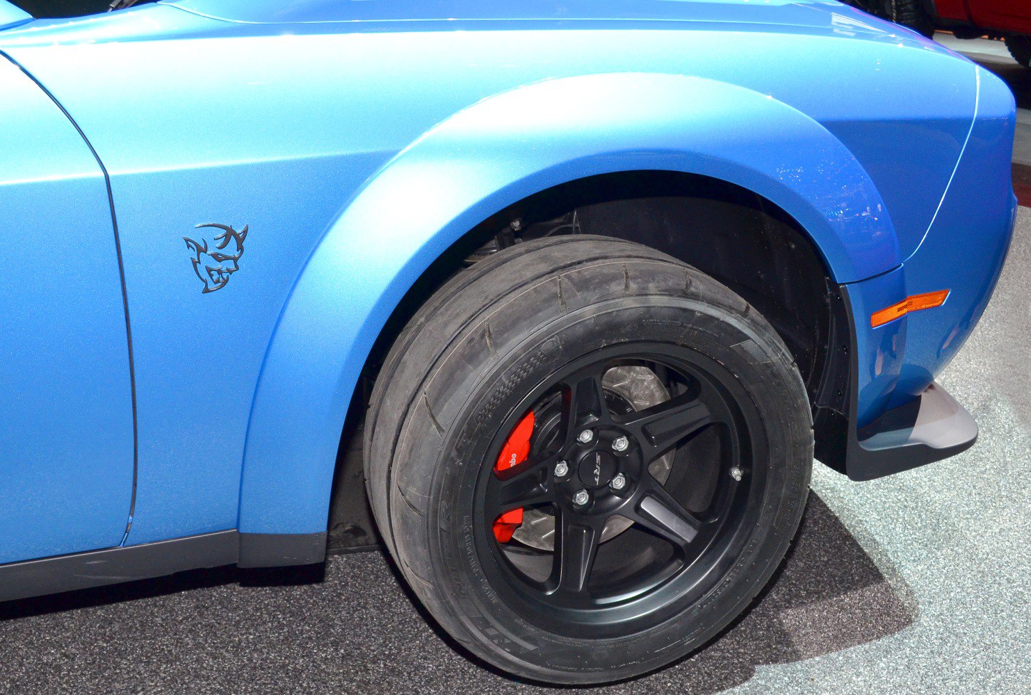 Widebody front wheel with black alloy rim and red brake caliper