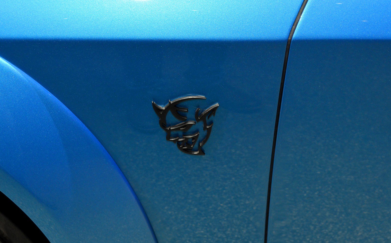 Black Hellcat badge on blue car fender