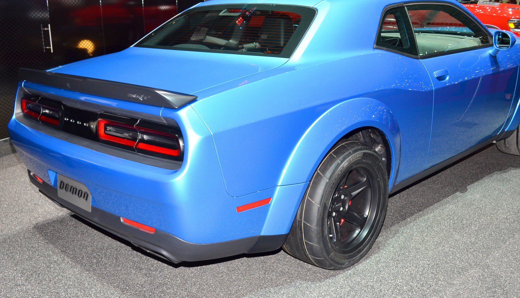 Rear view with taillights, spoiler, and wide rear wheel with black rim
