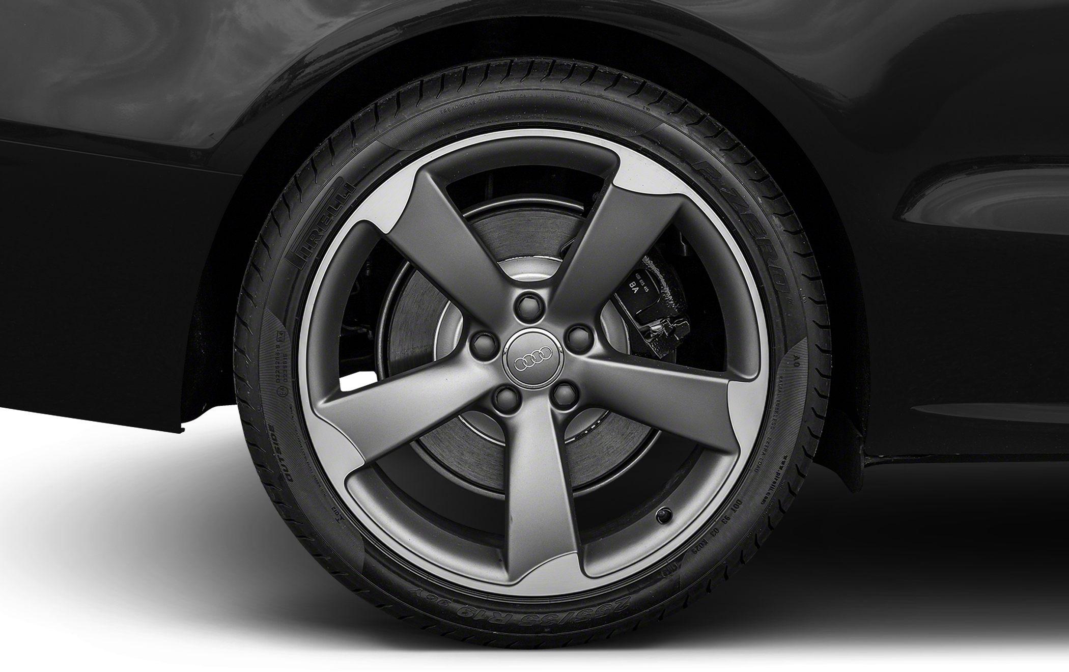Close-up of a matte silver alloy wheel with five thick spokes and visible brake caliper