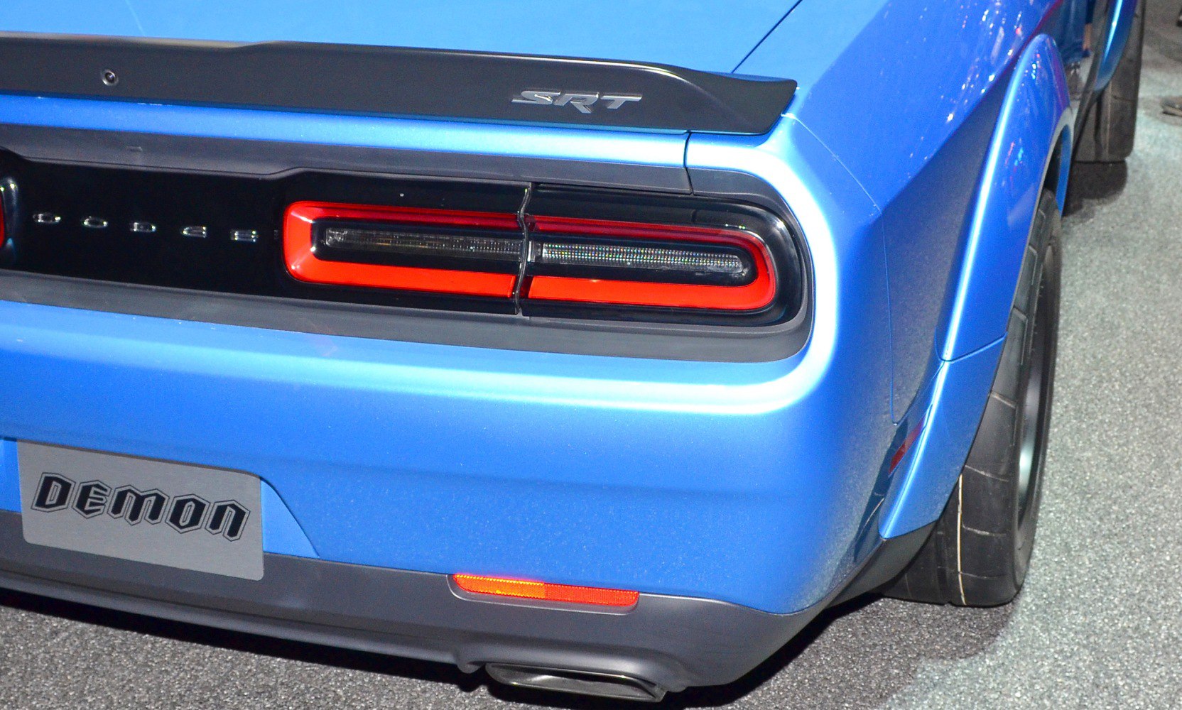Close-up of rear taillight and SRT badge on a bright blue 2015 muscle car