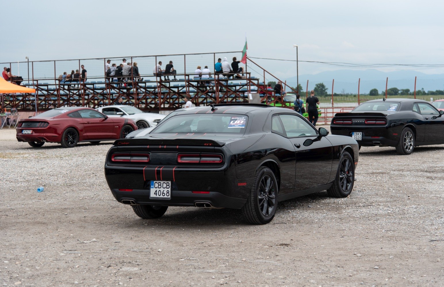 Rear view of a black muscle coupe with iconic taillights and GT badge