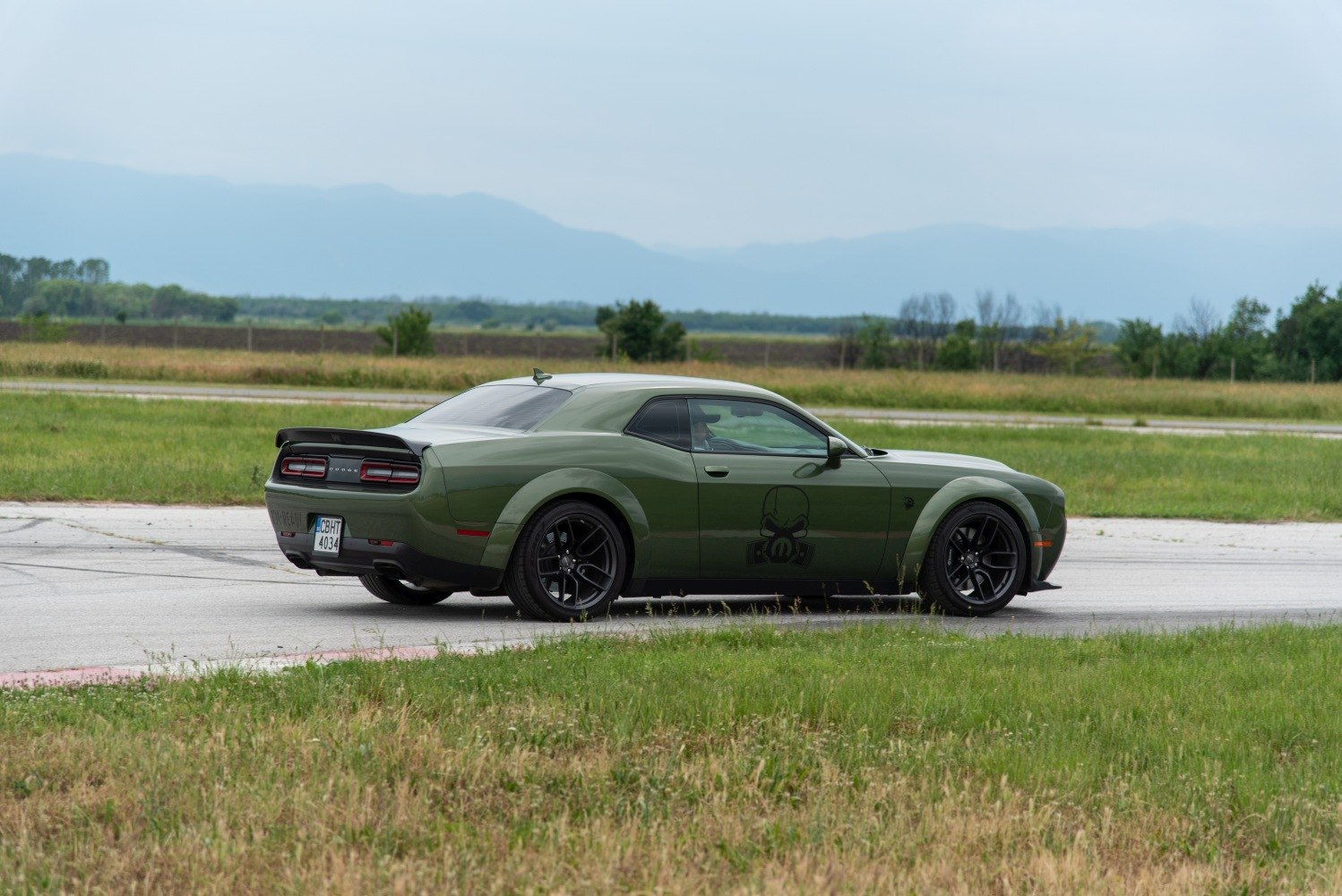 Rear side view showing wide fenders and black sporty wheels