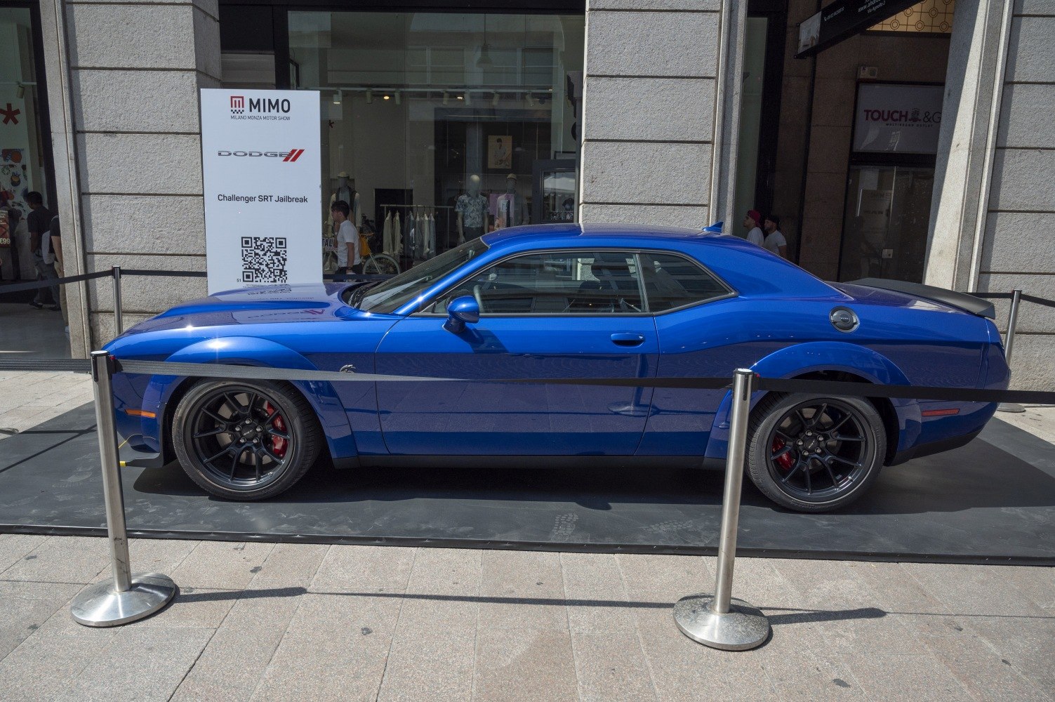 Blue muscle car side view with wide fenders and black rims
