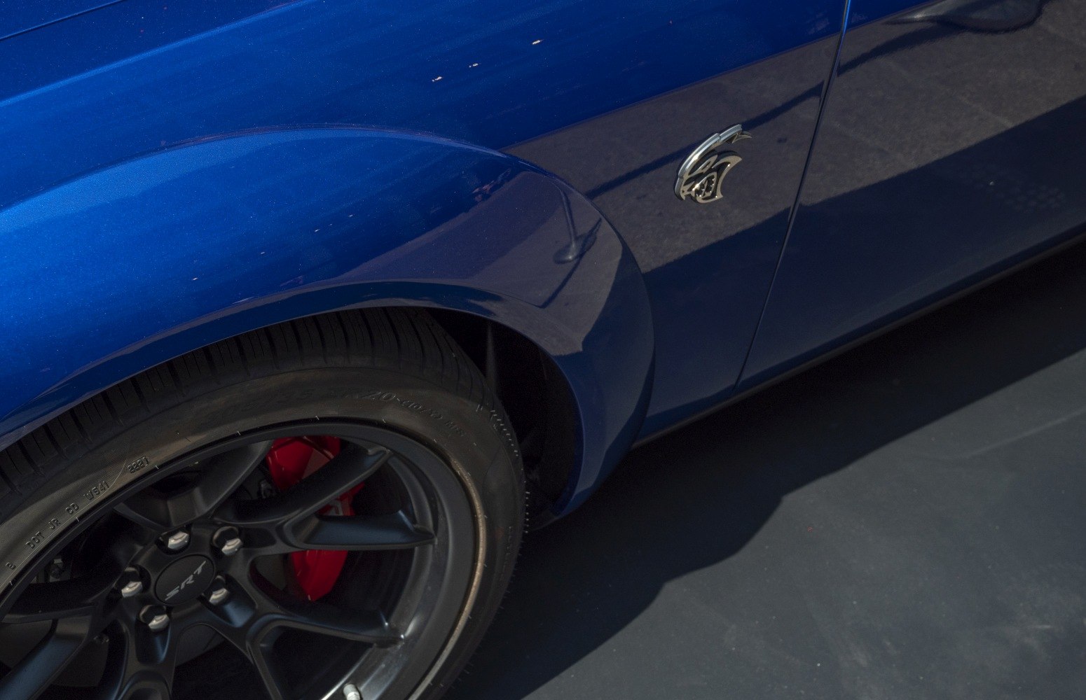 Black SRT wheel with red brake caliper, side emblem on blue body