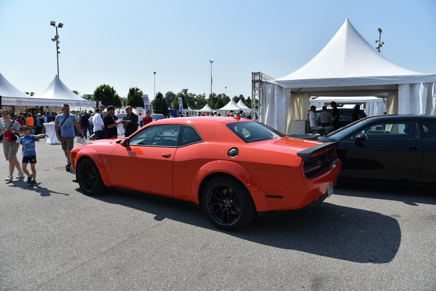 Orange widebody muscle car rear side with black wheels and rear spoiler