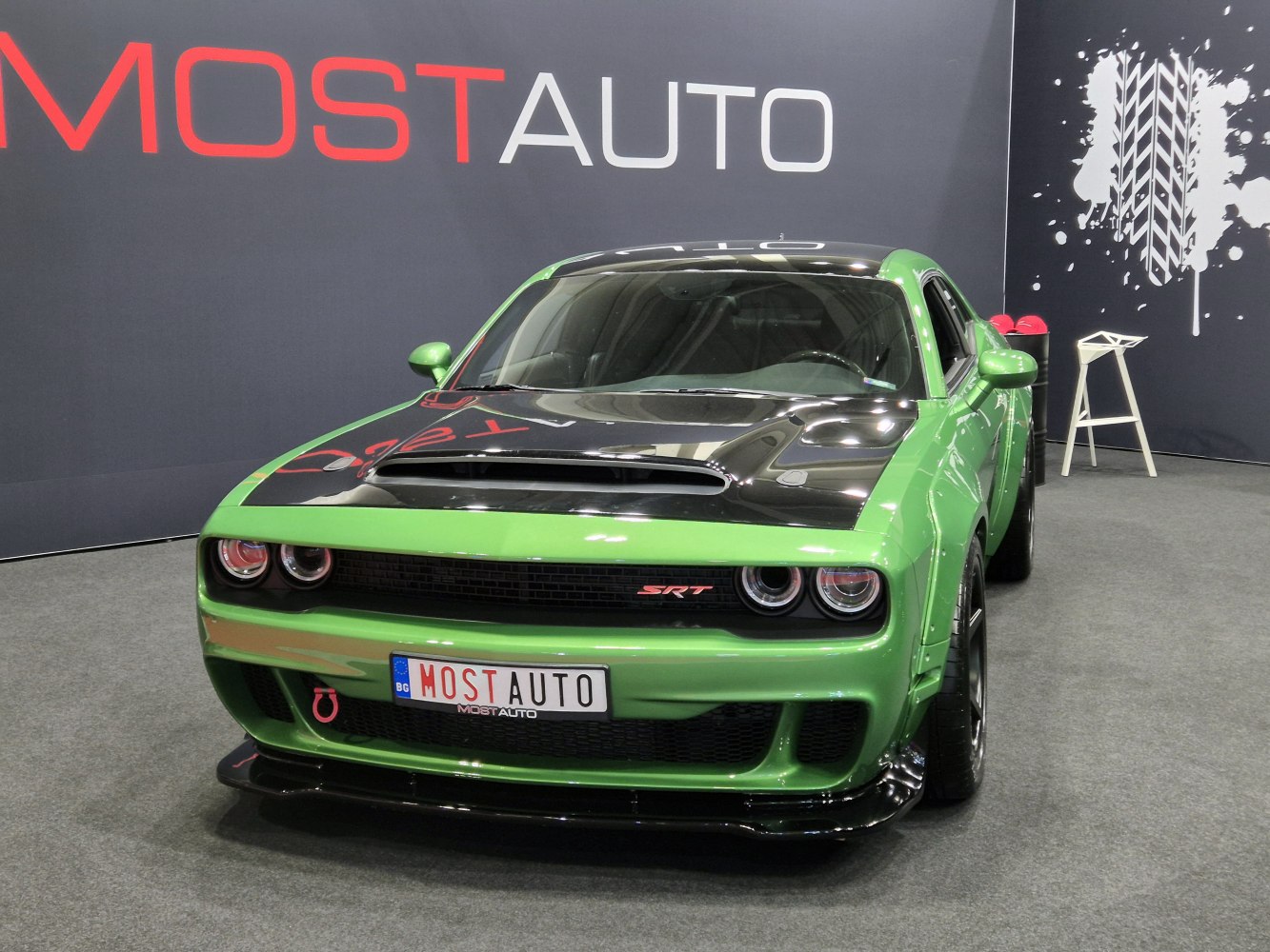 Front view of a muscle car with black hood scoop and dual round headlights