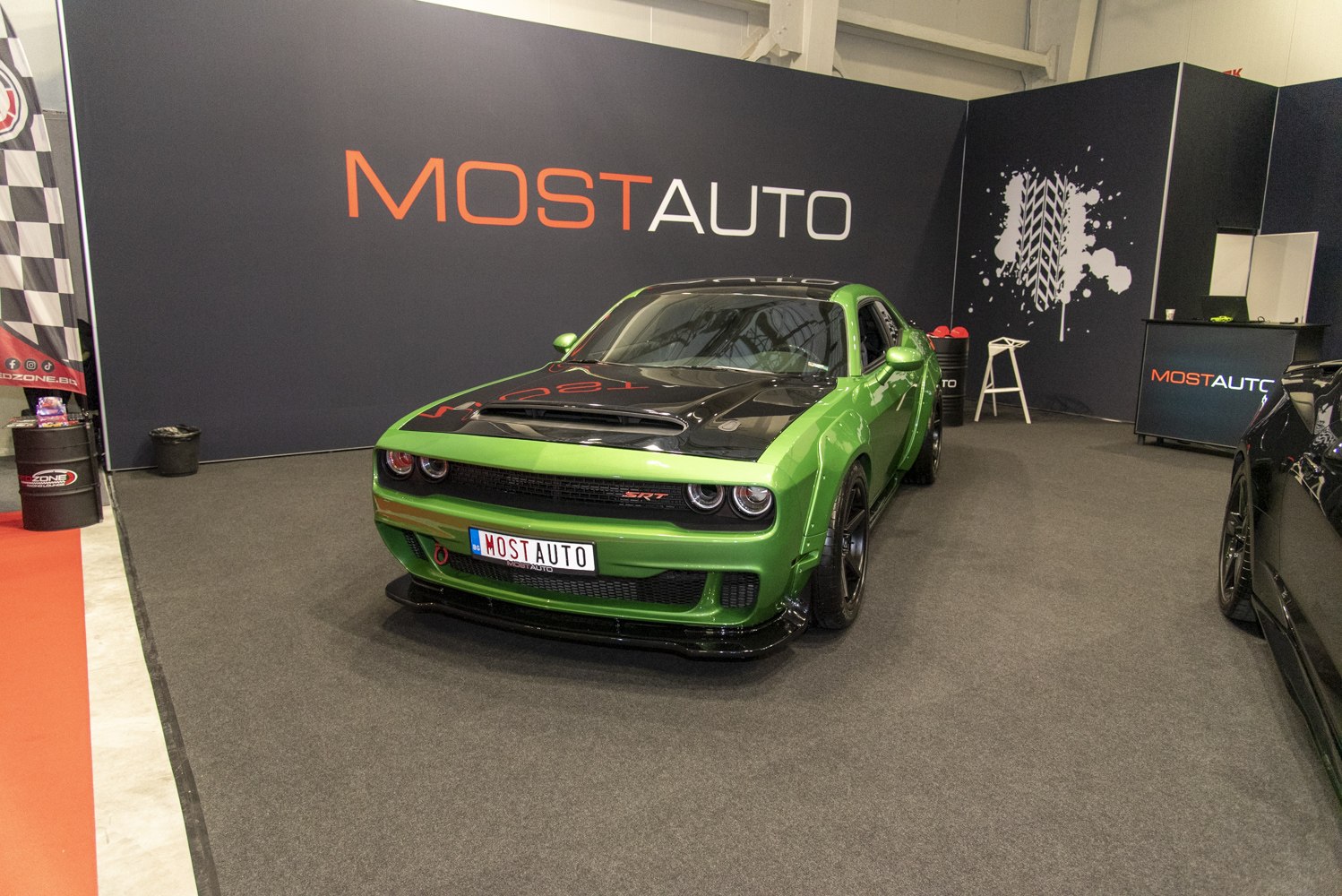 Green muscle car front view with black hood scoop and wide body kit