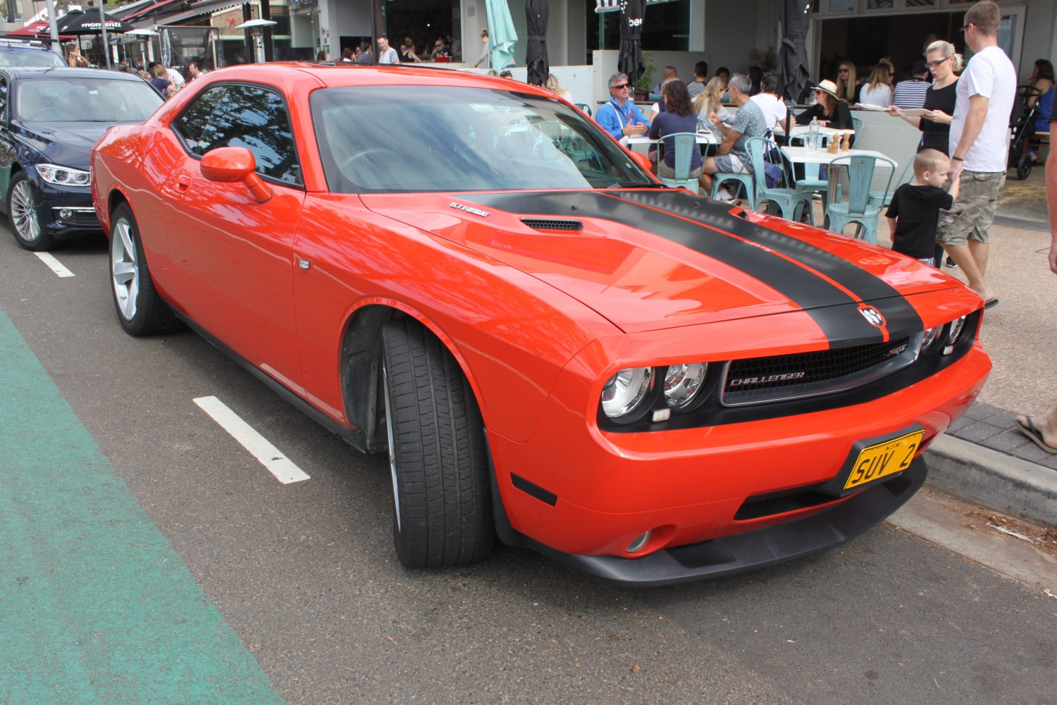 Red muscle car front-side with black racing stripes