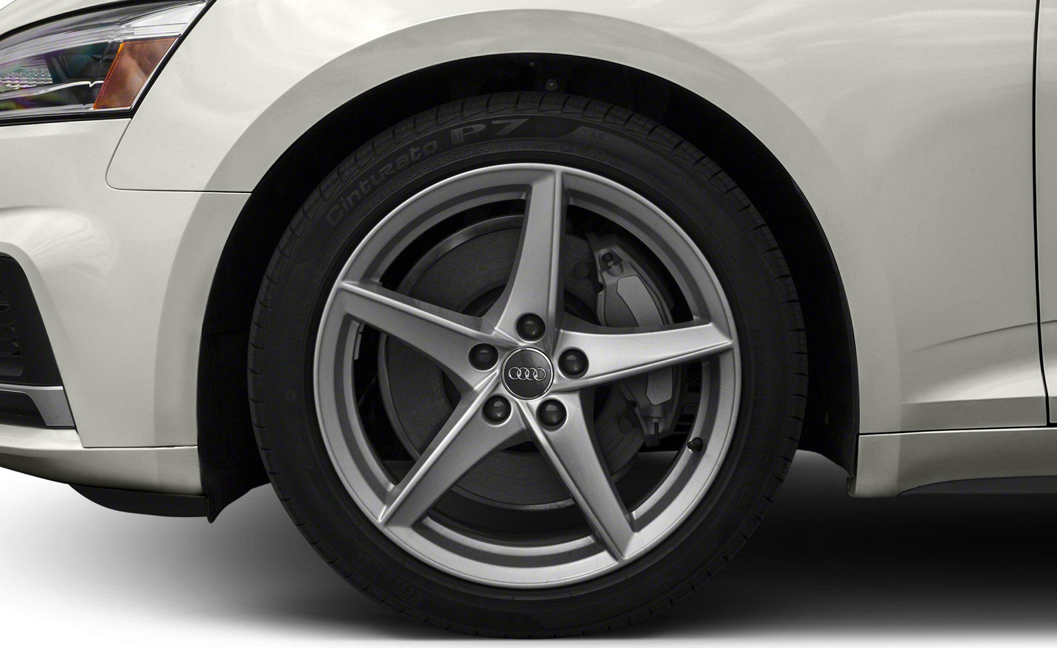 Five-spoke alloy wheel with brake disc and tire on a white vehicle
