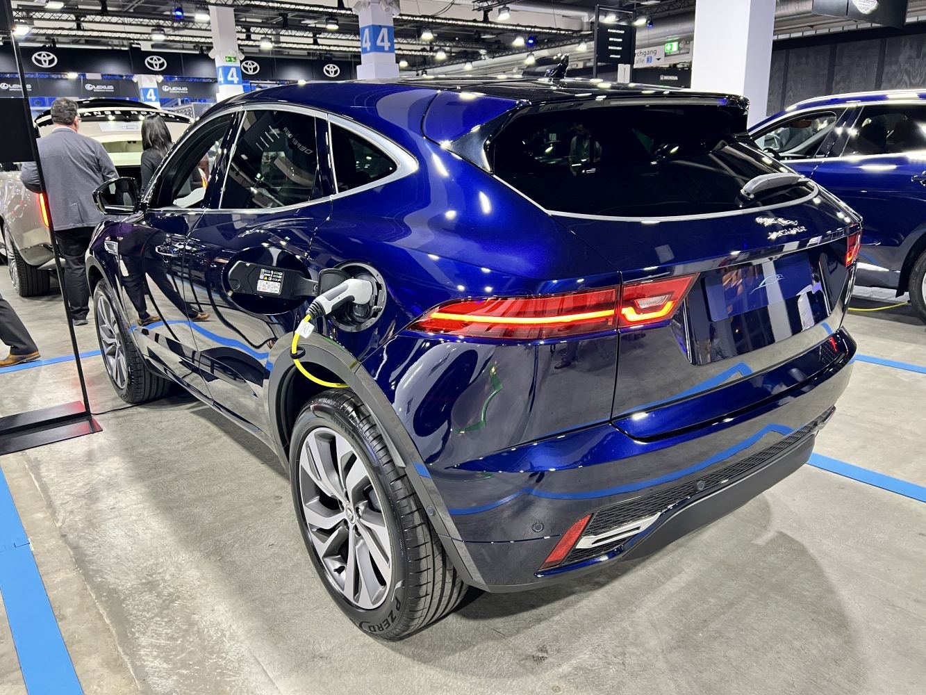 Sleek rear view of an electric SUV with charging port connected.