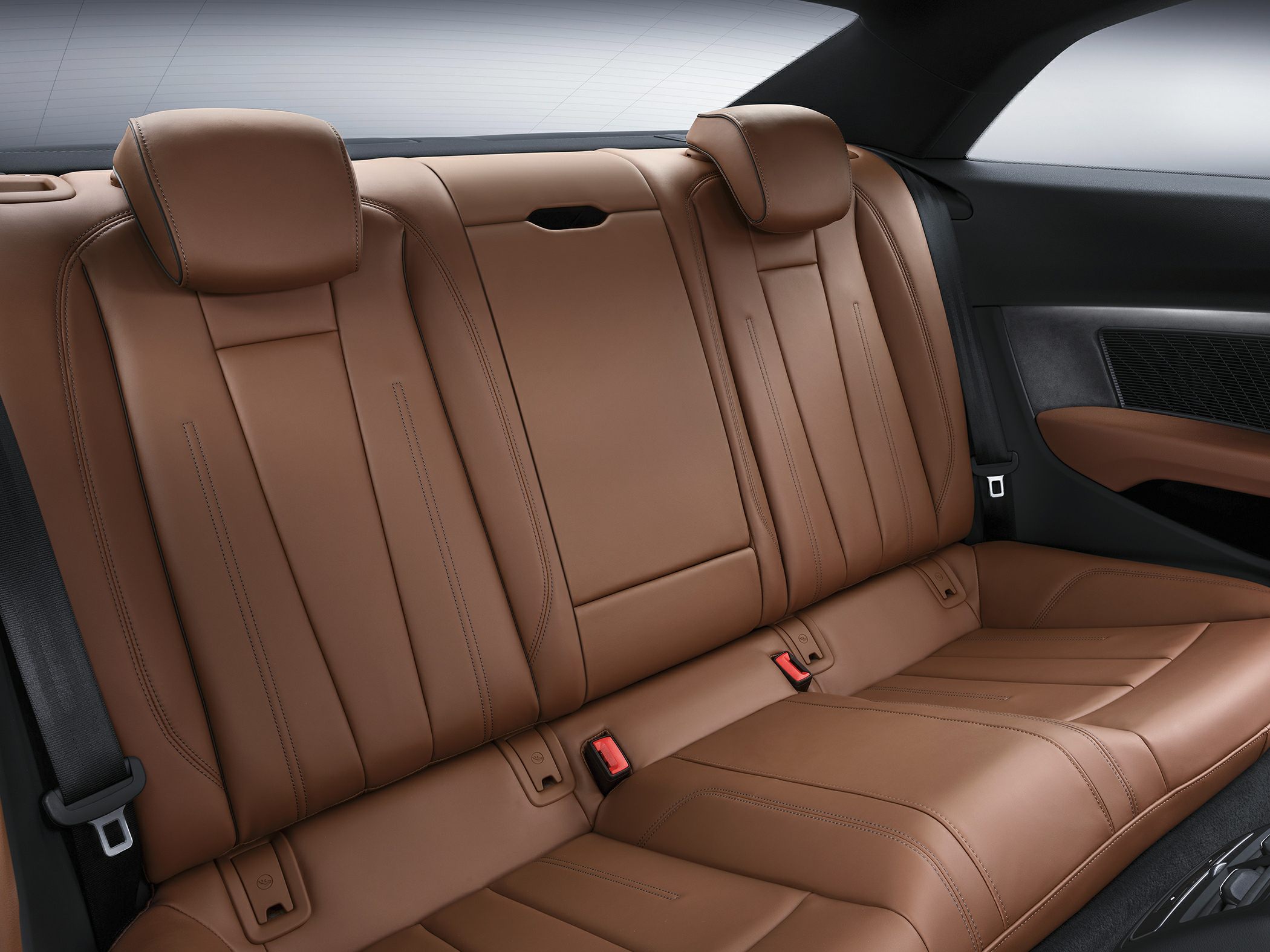Rear brown leather seats with headrests and detailed stitching