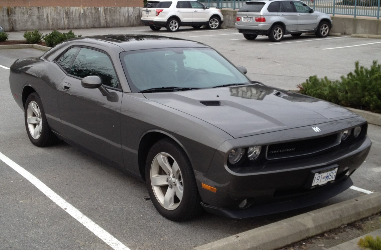 Muscular dark gray two-door coupe with prominent front grille and hood scoops