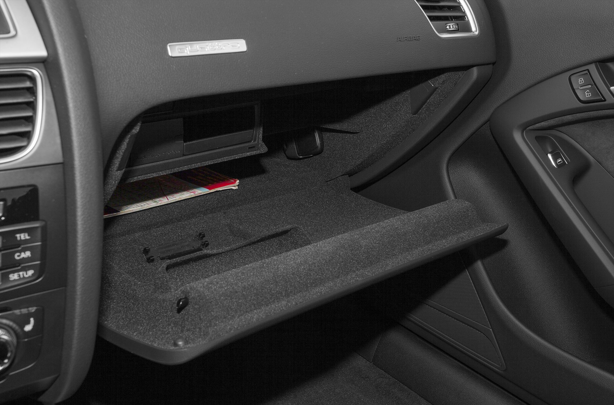 Open glovebox compartment inside the car with storage space and textured lining
