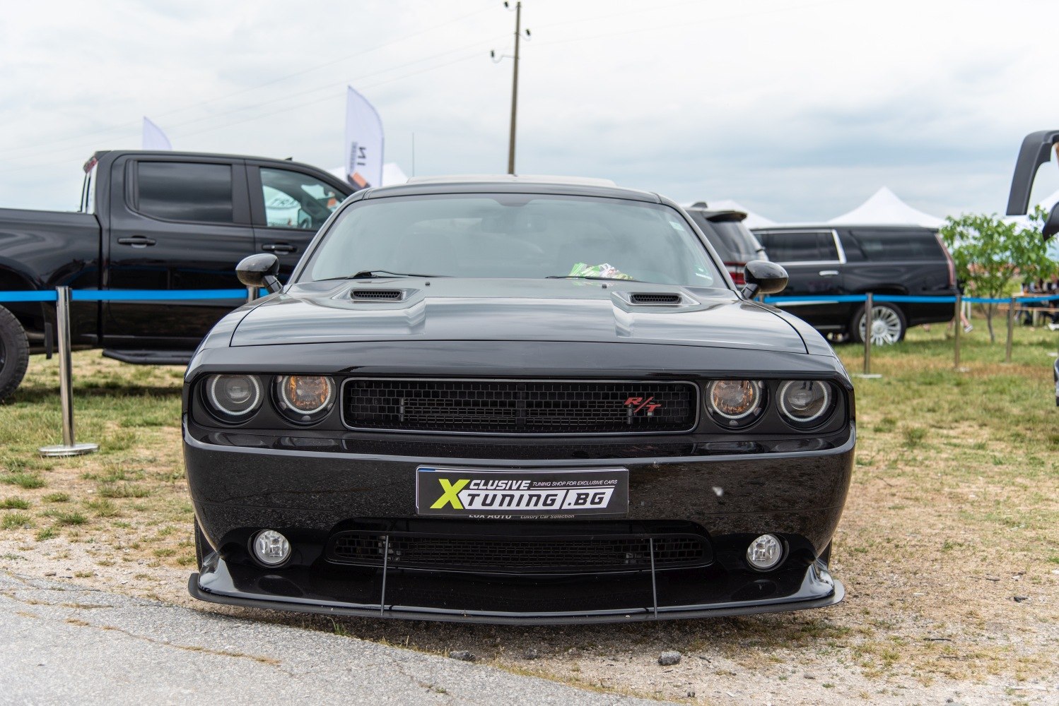Aggressive front view with hood scoops and grille of a black muscle car