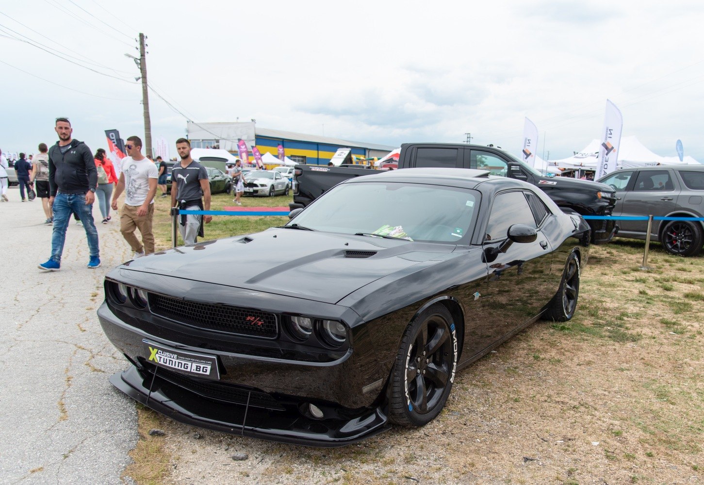 Black Dodge muscle coupe with aggressive front splitter and Mopar tires