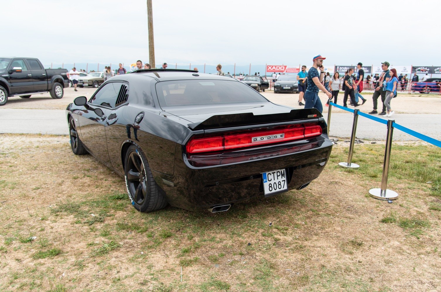 Rear view of a black muscle car with rear LED lights and rear spoiler
