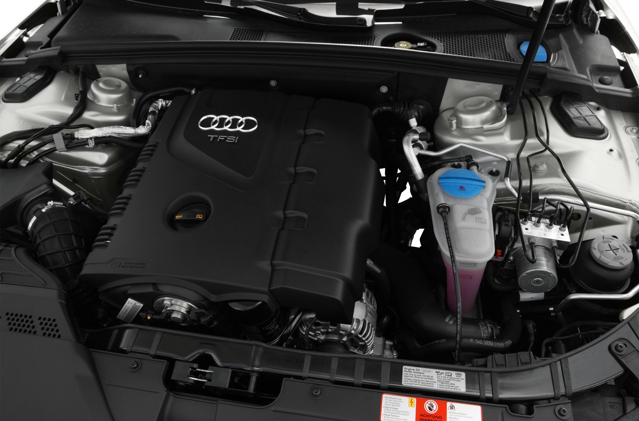 Audi TFSI engine compartment with prominent engine cover and coolant reservoir