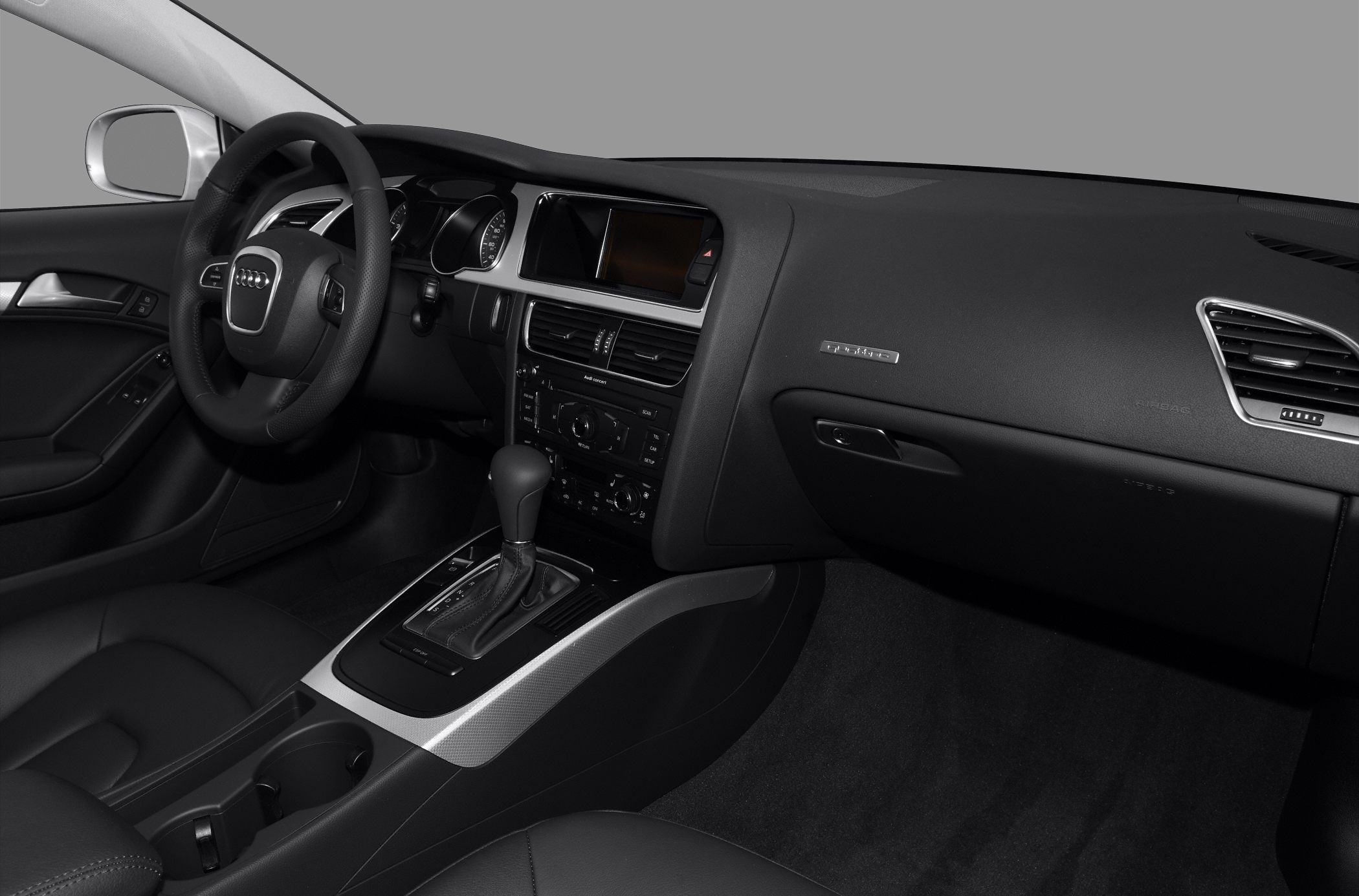 Interior dashboard, steering wheel, and center console with gear shift.