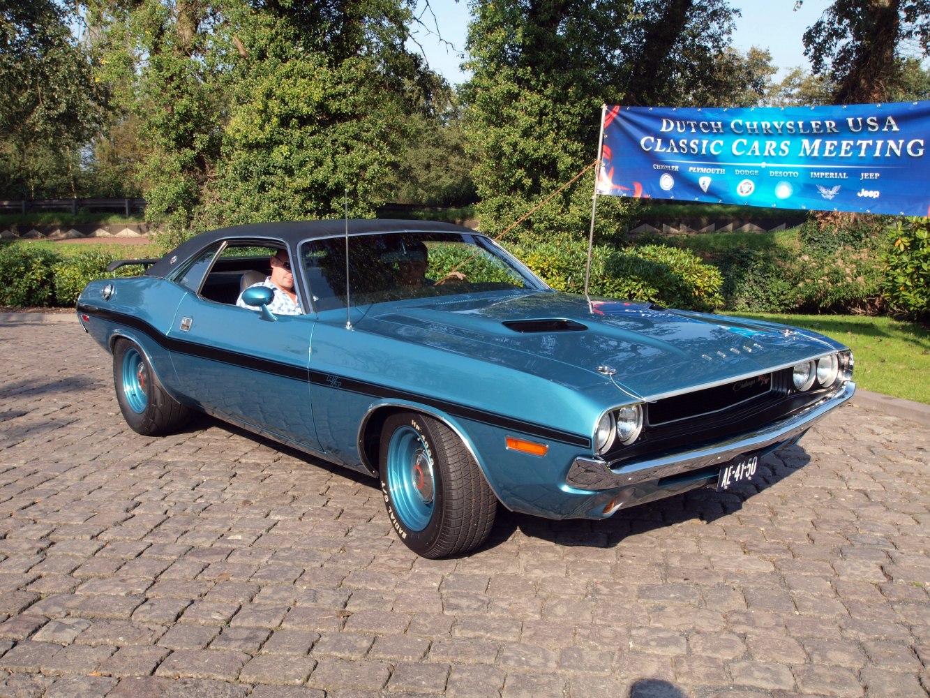 Muscle car with hood scoop, black vinyl roof, side stripes, and retro styling
