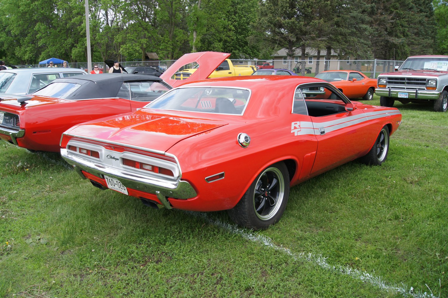 Red 1970 muscle car rear side with R/T stripes and chrome details