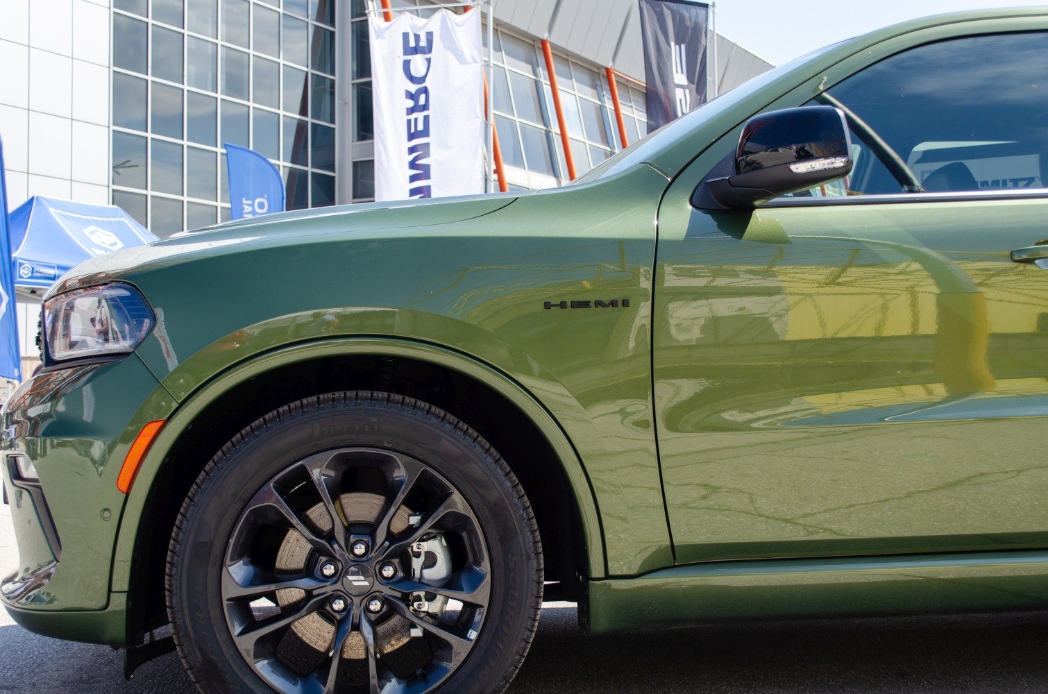 Green SUV side with HEMI badge and black alloy wheel.