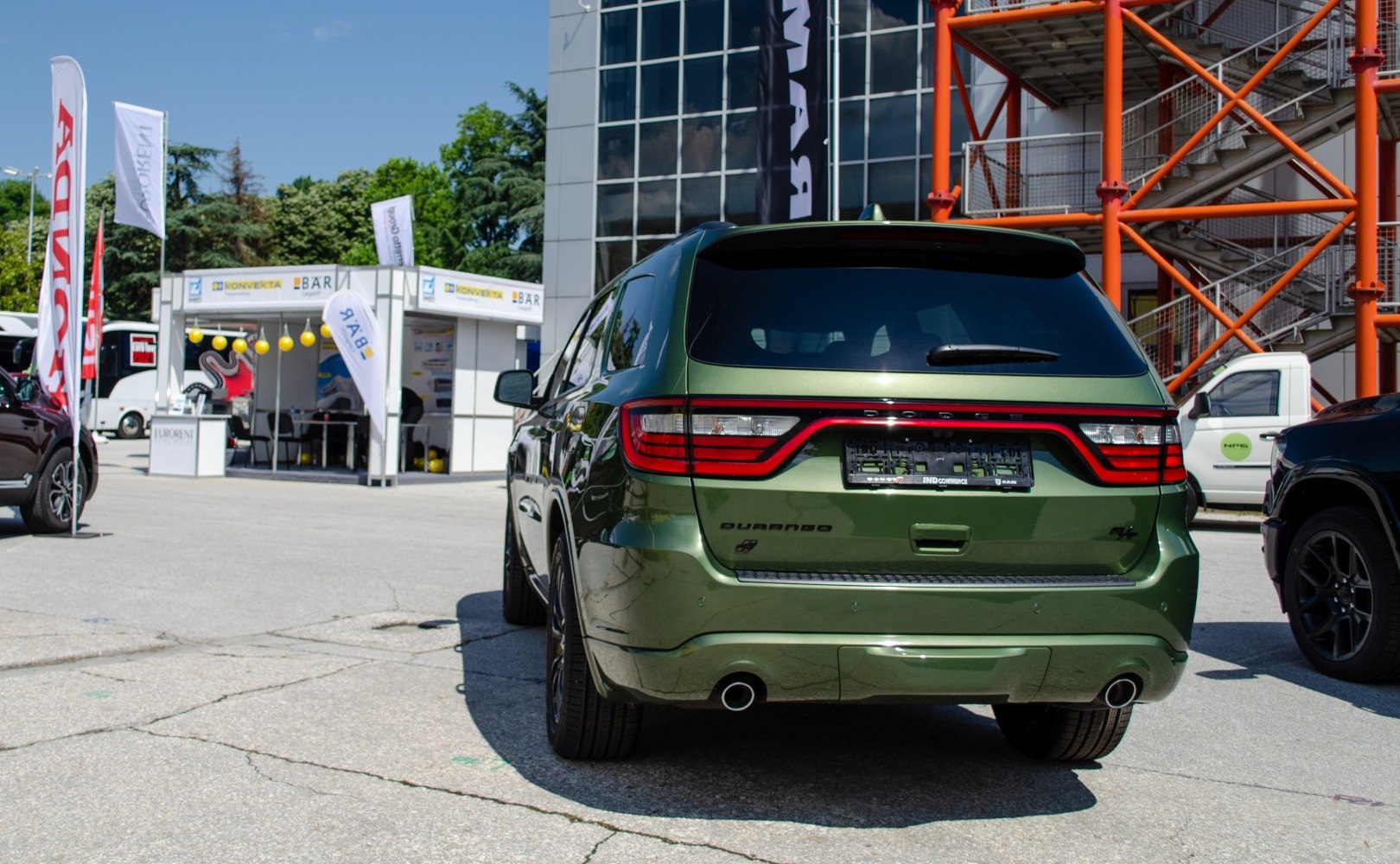Green SUV rear with full-width LED taillights and dual exhaust pipes
